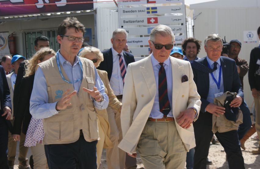 Caption: Prince Charles is briefed by UNHCR's Paul Stromberg during a visit to the Syrian refugee camps in Jordan. UNHCR/March 2013.
